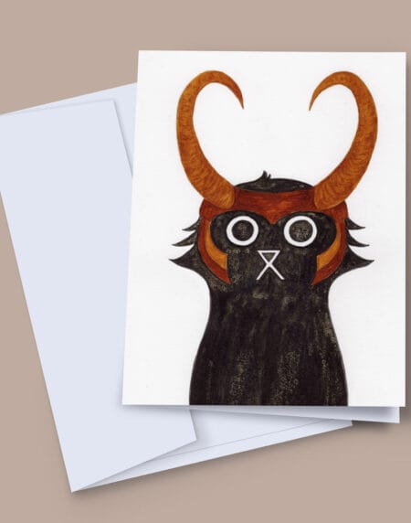 A 7x5 inch greeting card featuring an ink and salt black cat illustration wearing Loki's helmet