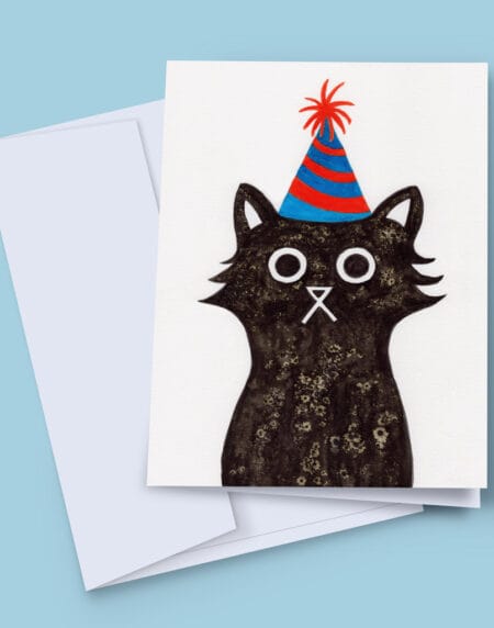 A 7x5 inch greeting card featuring an ink and salt black cat illustration wearing a party hat