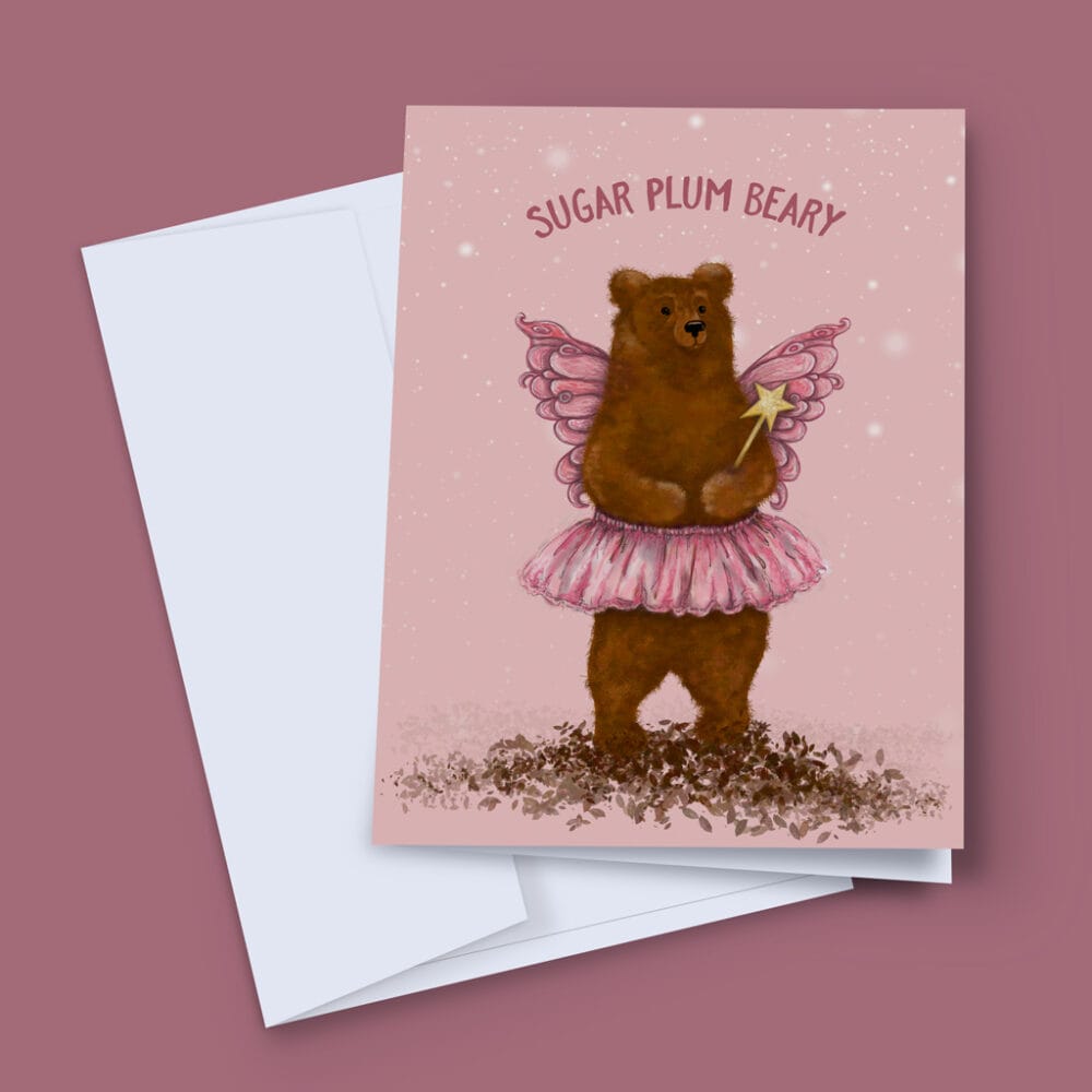 A Christmas Card depicting a fluffy brown bear in a pink tutu, and wings on a pink background, with wording Sugar Plum Beary