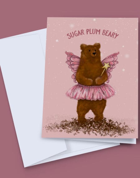 A Christmas Card depicting a fluffy brown bear in a pink tutu, and wings on a pink background, with wording Sugar Plum Beary