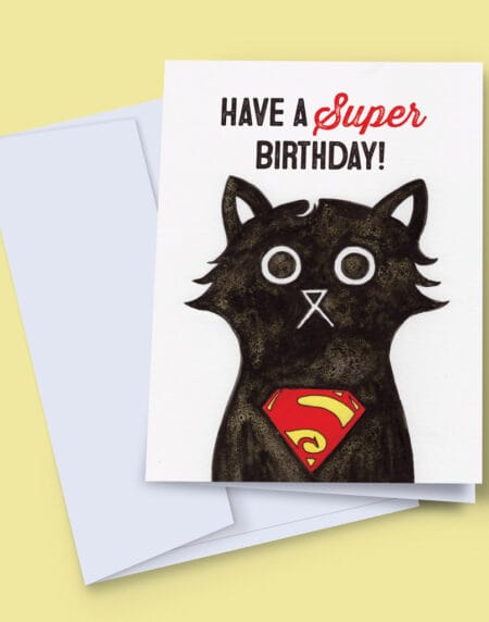 A 7x5 inch birthday card featuring an ink and salt black cat illustration wearing Superman's logo on his chest