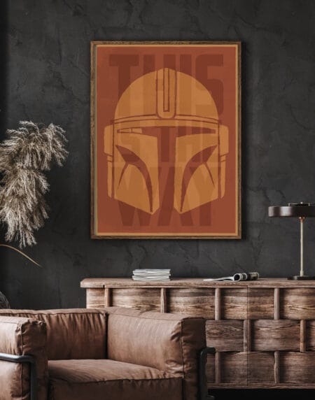 A typographic illustration of a Mandalorian helmet, with the words This Is The Way in rust and gold colours