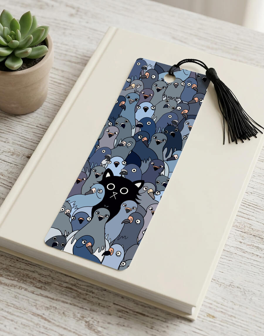 A wide-eyed black cat sits surrounded by a crowd of quirky illustrated grey pigeons staring back — the Cat Among the Pigeons bookmark, printed with a matt laminate finish and black tassel, 52mm x 148mm, 400gsm card